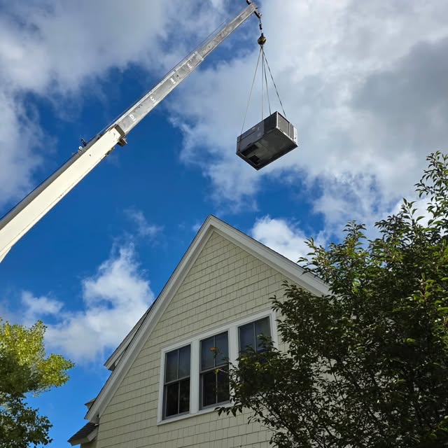 Crane lifting a new packaged HVAC unit onto a Temp Rise customer's home